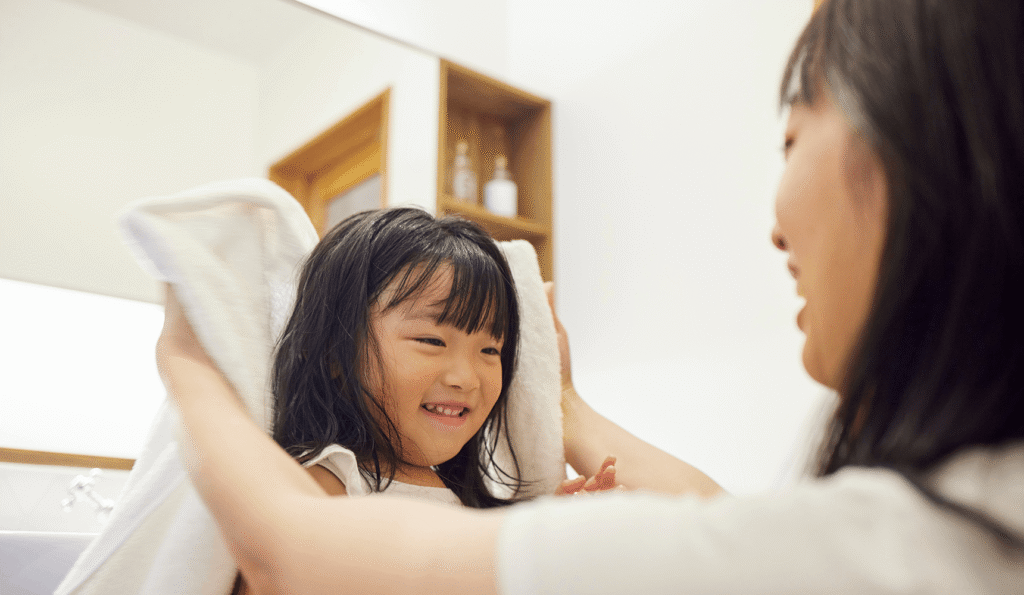 女の子の髪を拭く母親